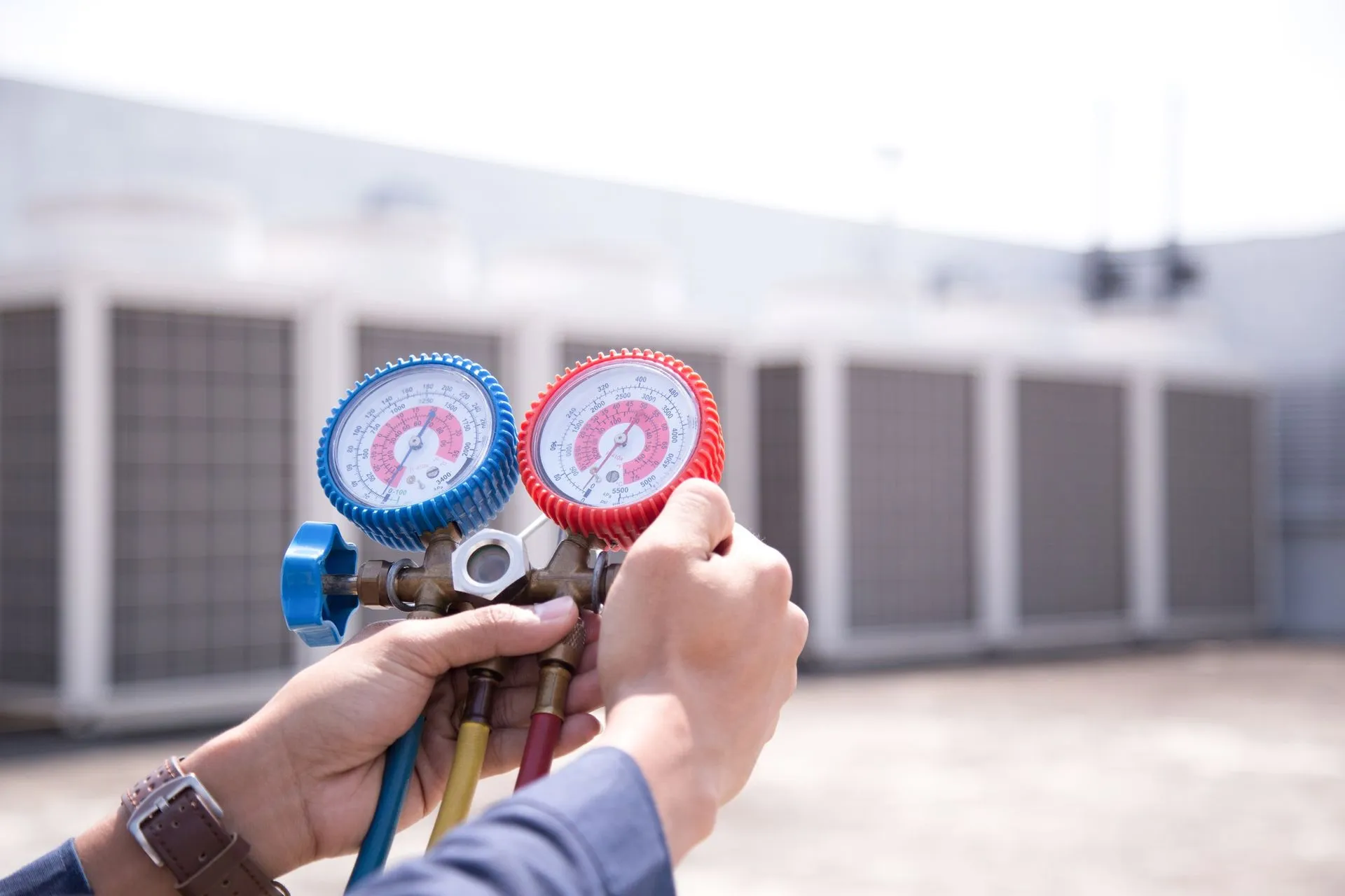 Rooftop commercial HVAC units being serviced by a technician.