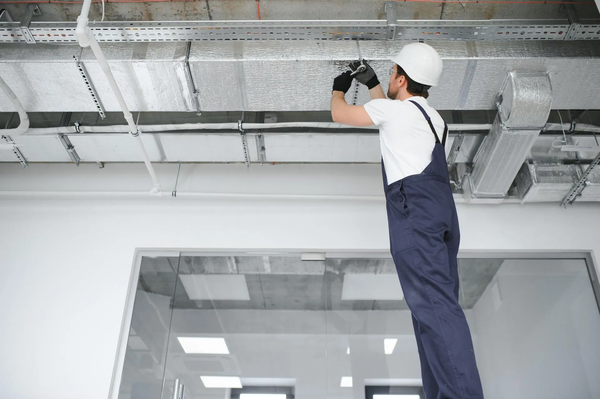 Professional cleaning residential air ducts with a specialized vacuum hose.