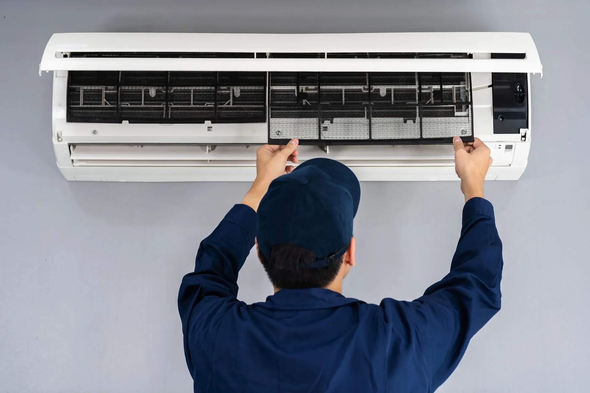 HVAC technician performing routine maintenance on a home heating and cooling system.