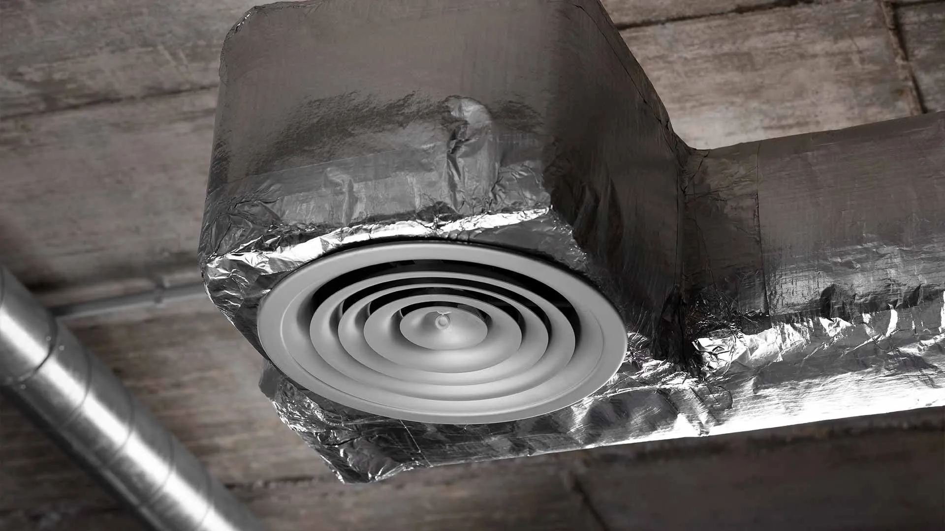 Technician inspecting residential air duct joints for gaps that need sealing.